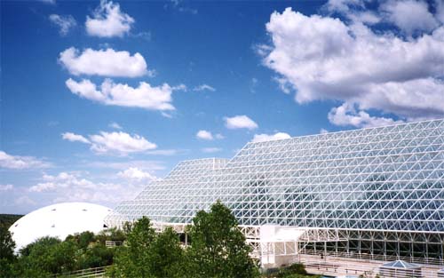 Exterior view of Biosphere 2 today, its glass pyramid and domes standing in the Arizona landscape as a tourist and research attraction.