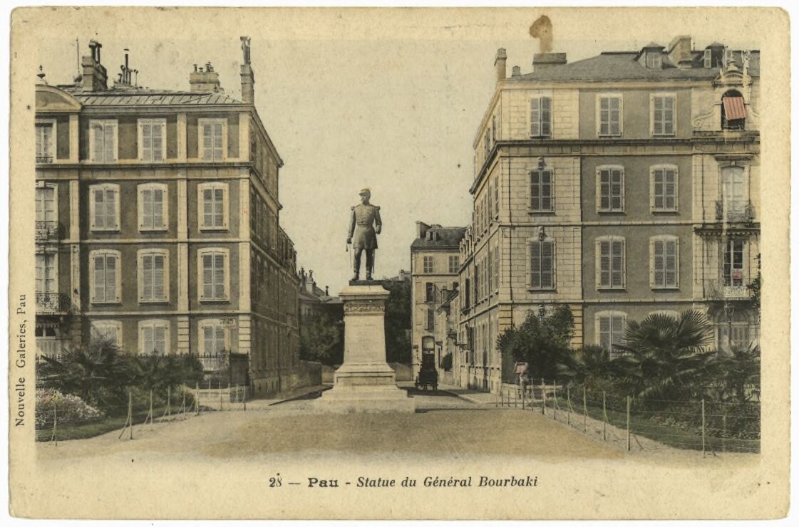 Hand-tinted vintage postcard of the Statue of General Bourbaki in a square in Pau, France, flanked by apartment buildings.