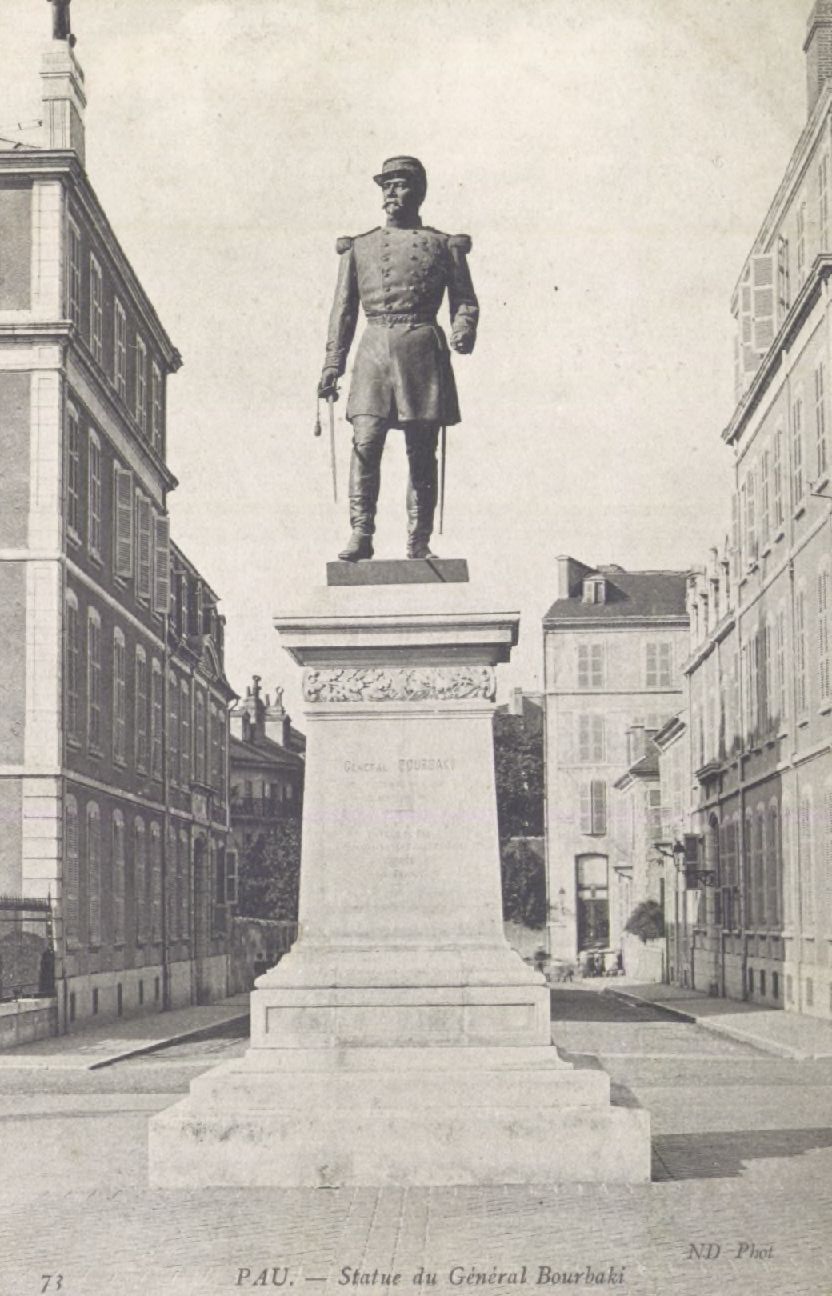 Tall vintage postcard of the Statue of General Bourbaki in Pau, viewed from below against the sky.