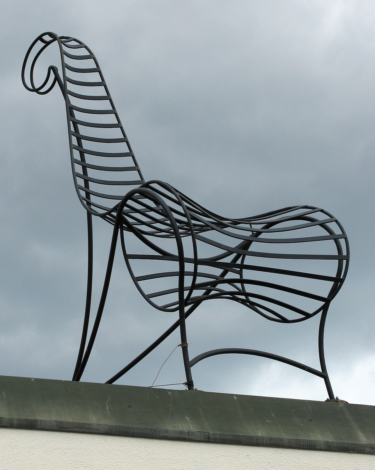 A giant 3:1-scale metal chair sculpture, the Maxistuhl Spine by André Dubreuil, standing on a street in Weil am Rhein-Haltingen, Germany.