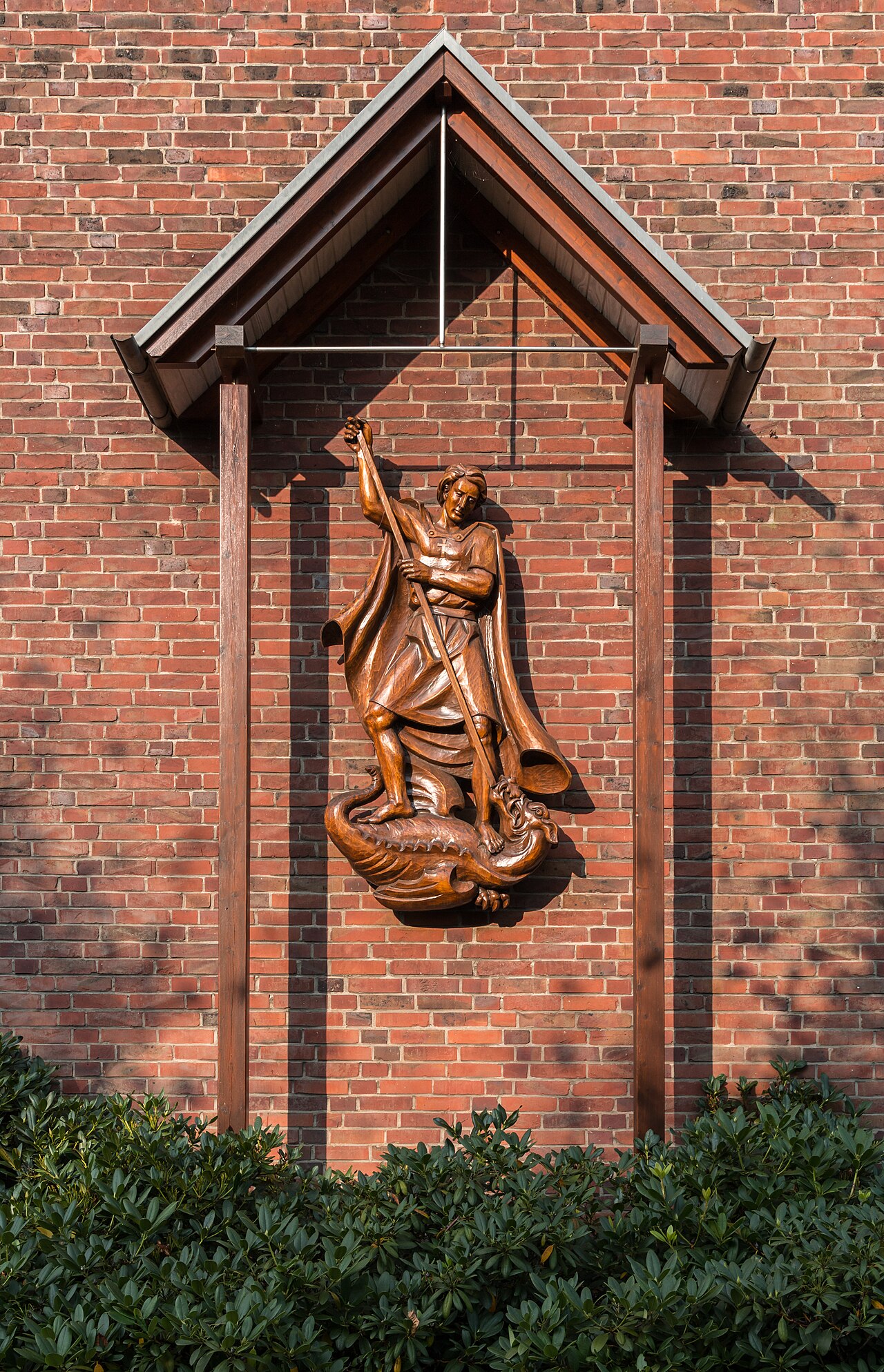 Painted wooden sculpture of Saint Michael inside a small chapel.