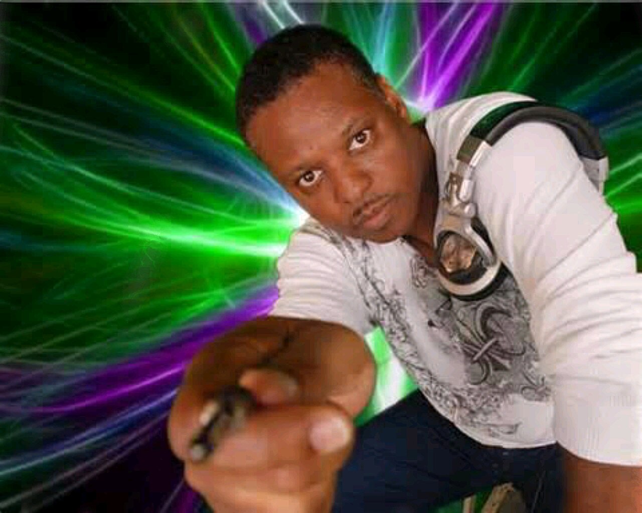 Promotional photograph of a house DJ, headphones around the neck, pointing toward the camera amid green and violet laser beams fanning out behind.