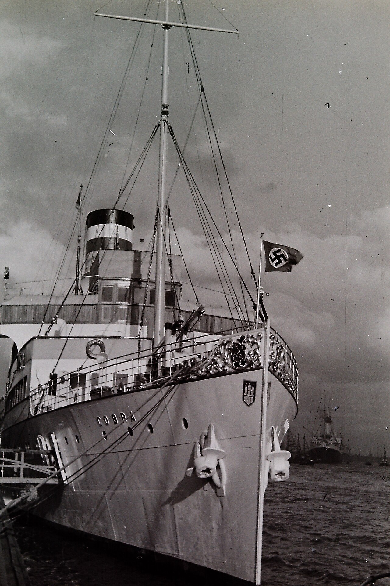 A black-and-white 1933 photograph of a small excursion steamship named Cobra at a quay.