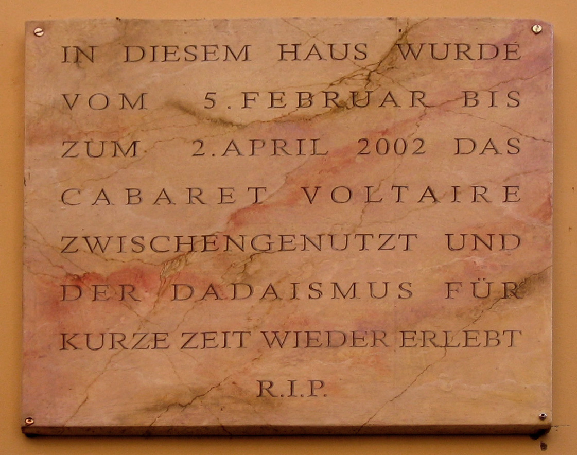 Marble memorial plaque on the Cabaret Voltaire building in Zürich, its German inscription ending 'DER DADAISMUS FÜR KURZE ZEIT WIEDER ERLEBT — R.I.P.'