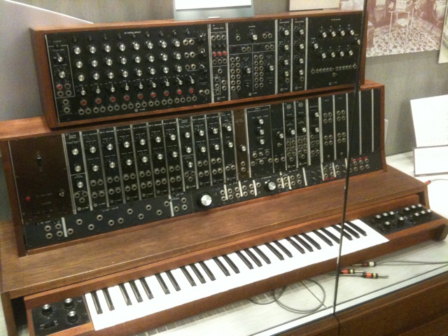 The first commercial Moog synthesizer from 1964, a wooden cabinet of modules held in a museum collection.