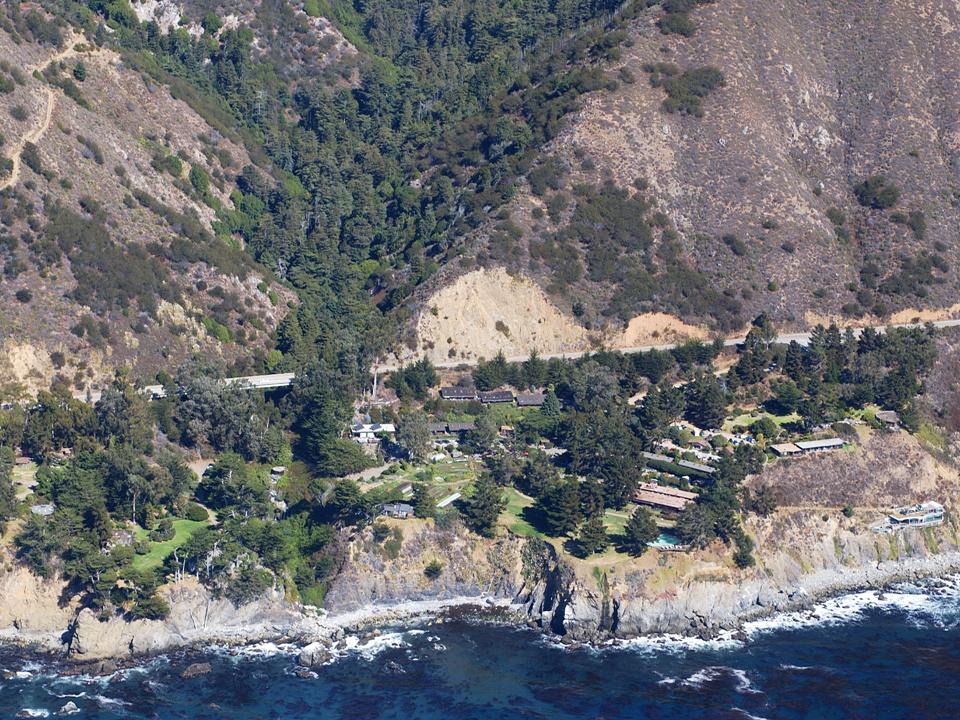 The grounds of the Esalen Institute at Big Sur — buildings and lawn set against the coastal hillside.