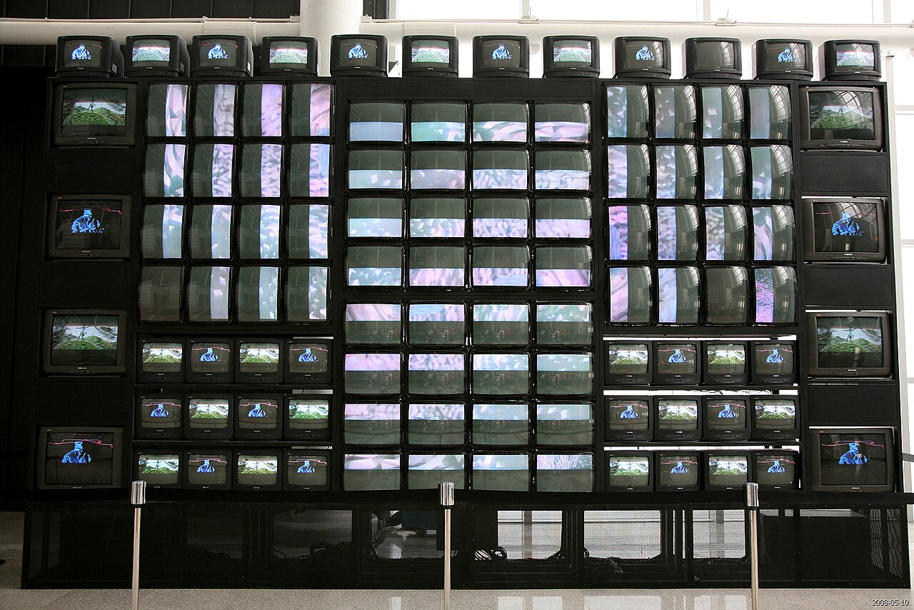 A towering wall of stacked cathode-ray televisions by Nam June Paik, each screen playing shifting video, installed in Gyeongju, South Korea.