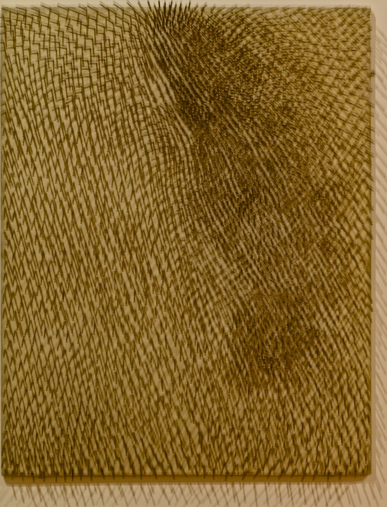 Günther Uecker's 1963 Composition: hundreds of nails driven into a board, their shafts and shadows sweeping into a vibrating spiral field.