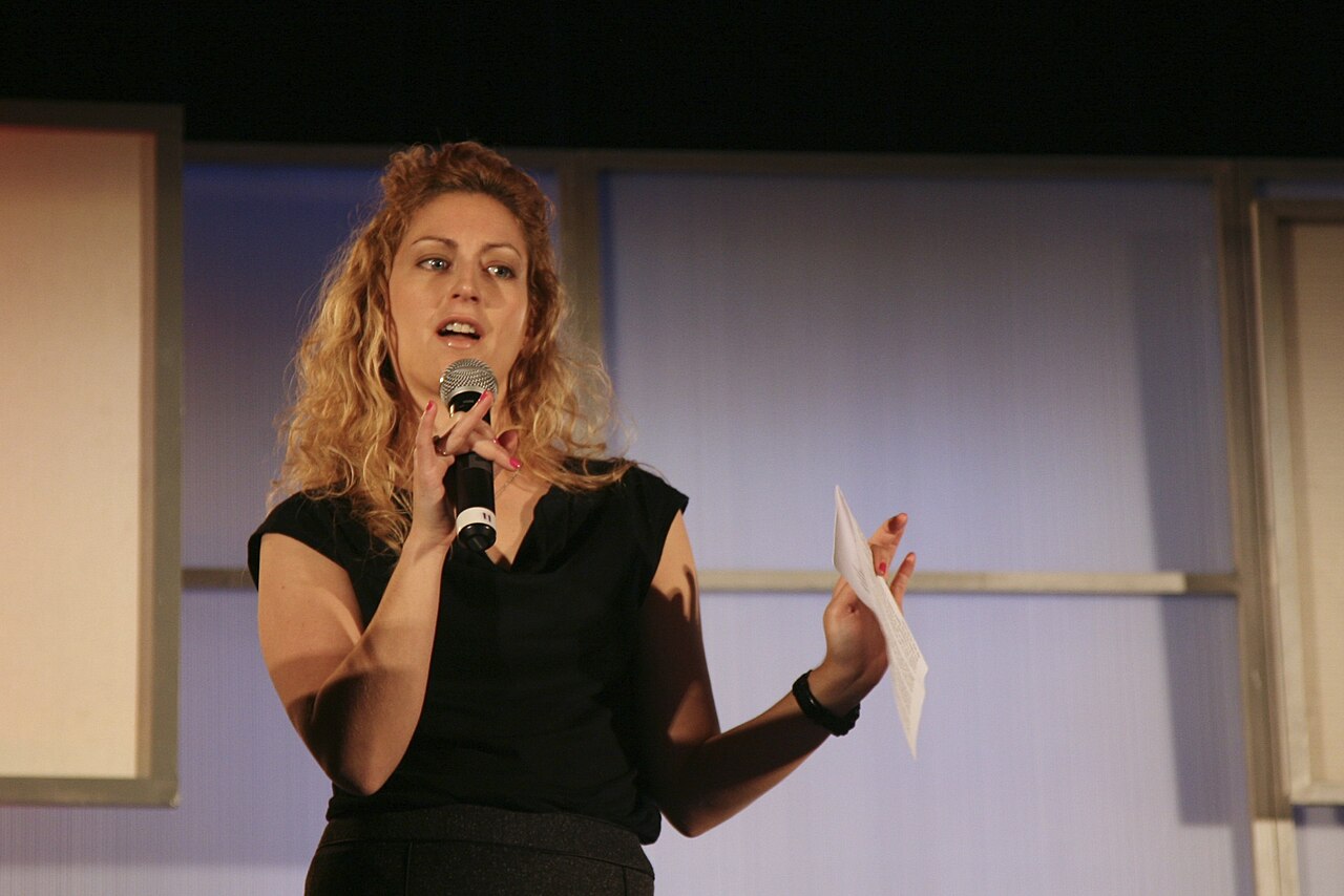 Jane McGonigal speaking at the eTech conference in 2009, gesturing at a podium.