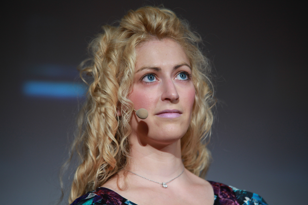 Jane McGonigal on stage at Meet the Media Guru in Milan, 2011, addressing an audience.