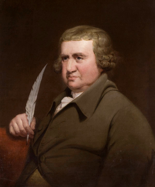 Oil portrait of Erasmus Darwin: a heavy-set man in an olive coat holding a white quill, emerging from a dark brown ground in candlelit chiaroscuro.