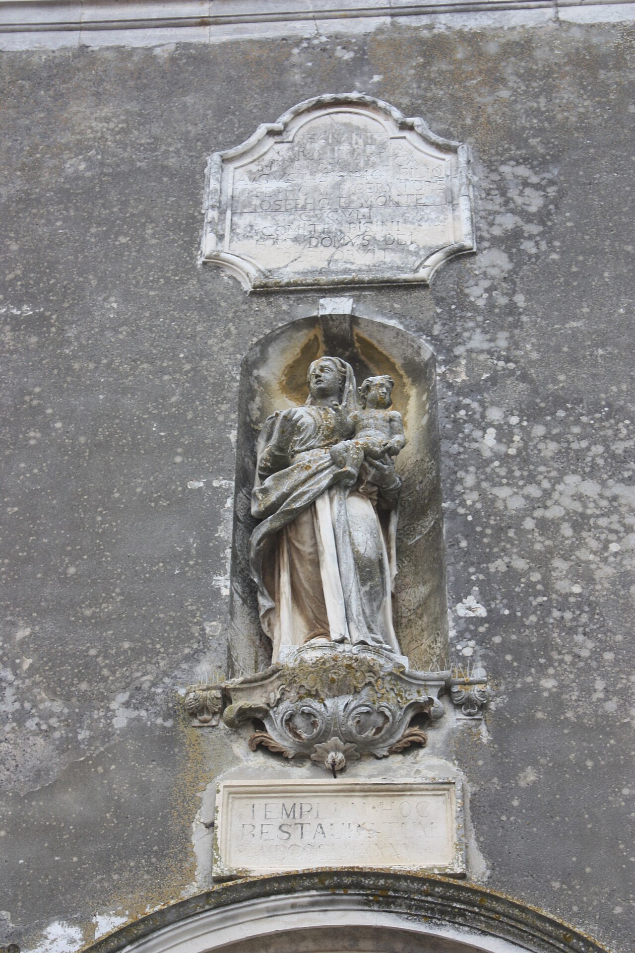 A weathered stone niche sculpture of Saint Mary holding the Christ child on a church facade, rendered in a cyan-lime duotone with scanlines.