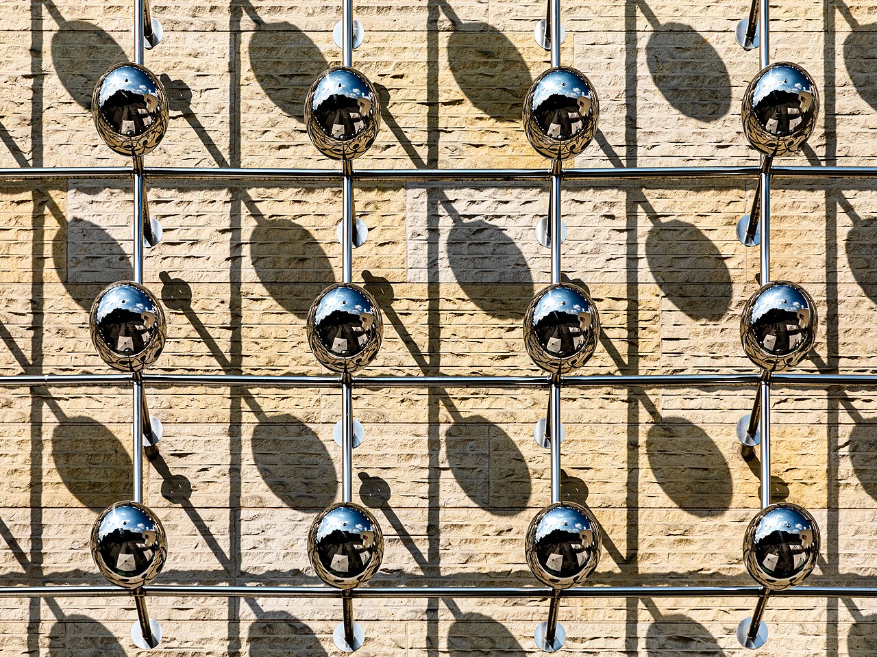 Close detail of Otto Piene's kinetic light sculpture "Silberne Frequenz" — a dense silver grid of perforated metal glinting under directed light.