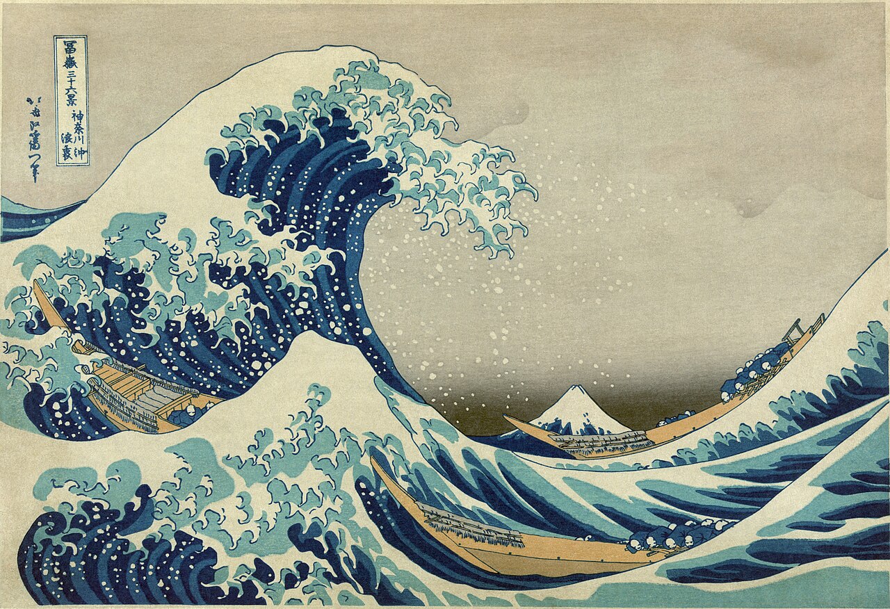 Woodblock print of a towering breaking wave with clawed foam, boats beneath it and Mount Fuji in the distance.