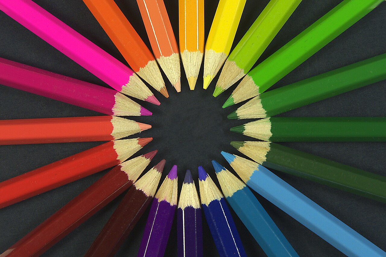 A close cluster of sharpened coloured pencils, tips converging — the tools of the hand.