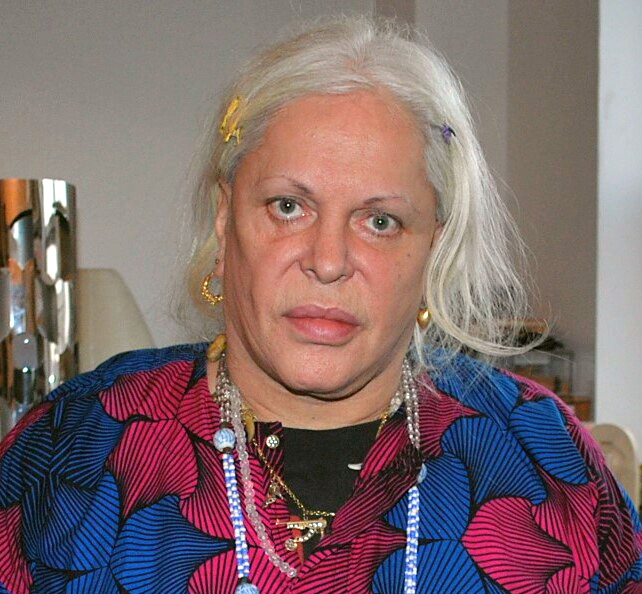 Genesis P-Orridge holding up a Universal Life Church certification inside their New York home, 2014.