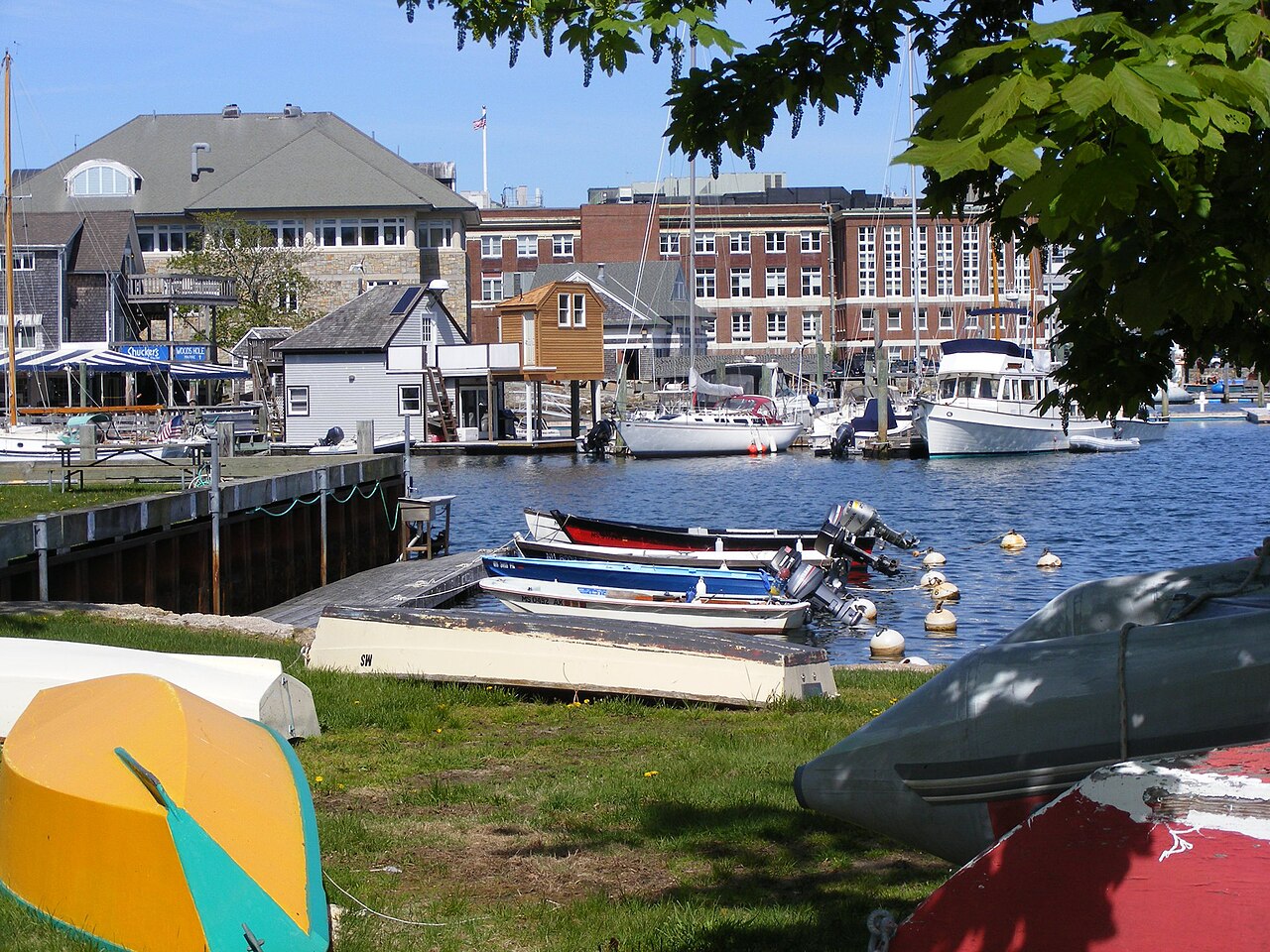 The Marine Biological Laboratory buildings at the water's edge in Woods Hole, Massachusetts, seen across the harbor.